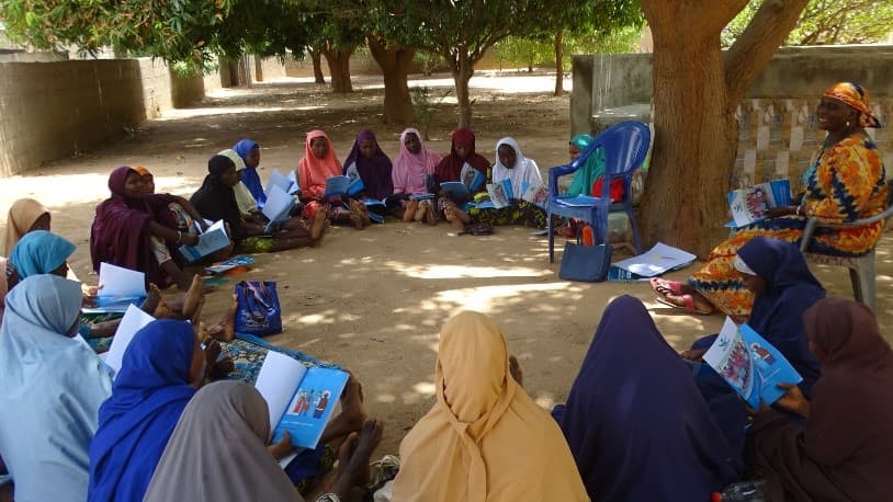 Women reading educational materials in a community circle
